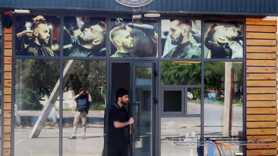 zdjęcie mężczyzny przed salonem fryzjerskim